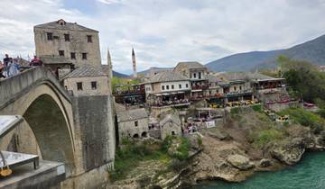 Historic bridge and traditional buildings with a scenic river.
