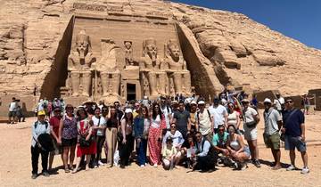 Large group of tourists posing in front of an ancient temple.