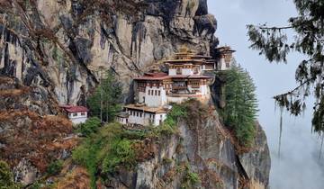 Taktshang Monastery perched on a cliff with fog rolling in.