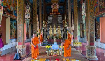 Monks in an ornate temple with religious statues.