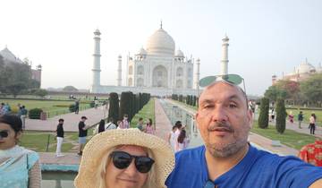 Couple posing in front of the Taj Mahal.