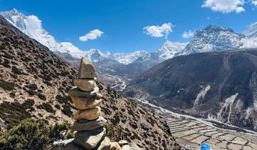 Cairn in front of a vast mountainous valley.