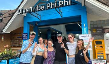 Group in front of Dive Tribe sign at a diving center.