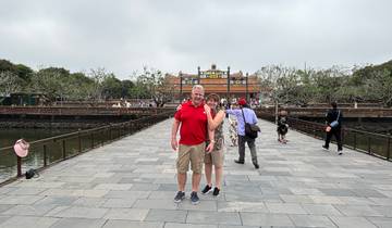 Couple on a bridge in front of a historical building.