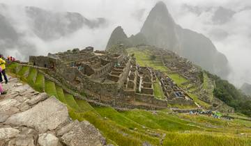 Machu Picchu ruins with misty mountains in the background.