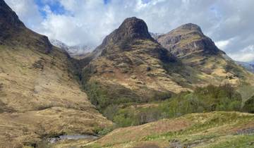Mountain range in Scotland under a mostly cloudy sky.
