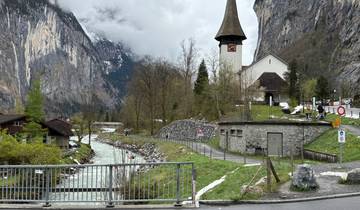 Church and river with mountains in the background.