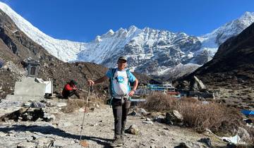 Mountaineer standing before snow-capped peaks.