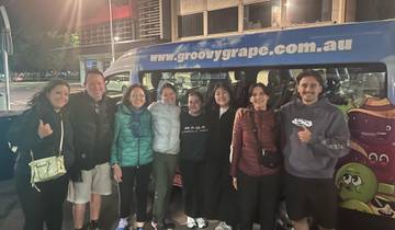 Group of people posing in front of a van with a logo.