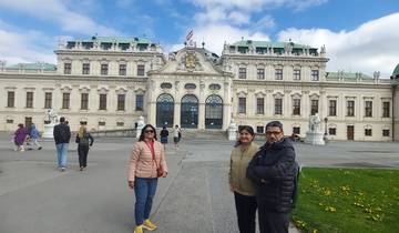 A group of people outside a grand historic palace.