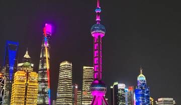 Night cityscape showing colorful illuminated skyscrapers, including the Oriental Pearl Tower in Shanghai.
