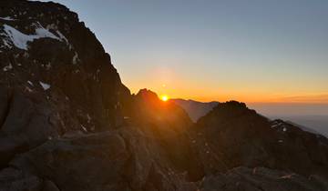 Sun setting behind a mountain ridge.