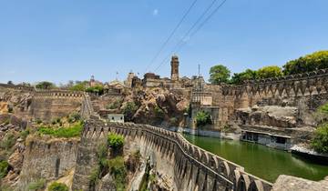 Panorama of an ancient fort with a water body on a cliff.