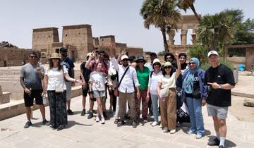 Group of tourists with a backdrop of ancient Egyptian structures.