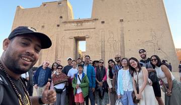 Group of tourists posing in front of an ancient temple.
