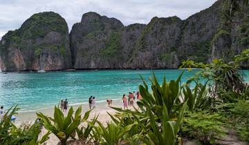 Beach with turquoise water and rocky cliffs.