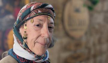 Woman in traditional Turkish attire with decorative coins and patterns.