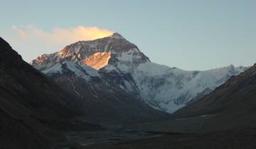 Snow-capped mountain with sunlight illuminating the peak.