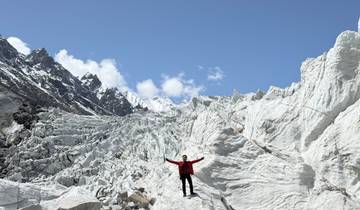 Person with arms raised on a snow-covered glacier.
