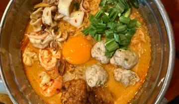 Bowl of ramen with shrimp, egg, and vegetables.