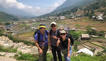 Trekkers standing with a scenic view of terraced fields.