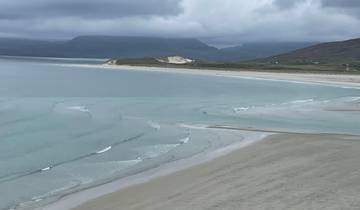 Beautiful beach with clear waters and distant hills.