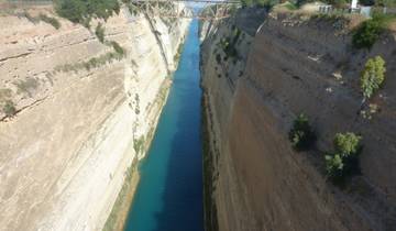 Deep canal flanked by rocky walls, spanned by a bridge.