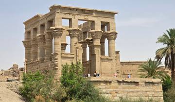 Ancient Egyptian temple with columns and tourists.