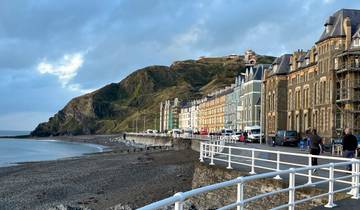 Beachfront view of Aberystwyth with a promenade and colorful buildings.