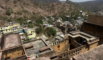 Aerial view of a fort complex and surrounding town in a hilly area.