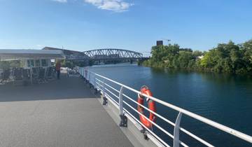 View from a boat deck with bridge crossing over a river.