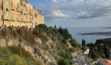 Majestic view of a hillside villa overlooking the sea.