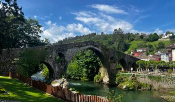 An ancient stone bridge over a lush river valley.