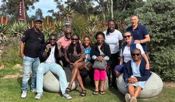 Group of people sitting in a garden setting.