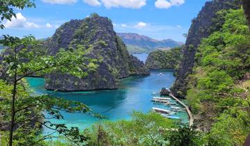 Scenic lagoon surrounded by lush greenery and cliffs.
