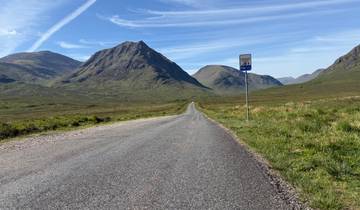 A scenic road leading through hills with a clear sky.