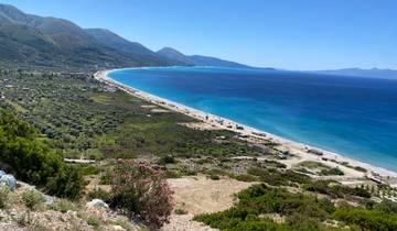 A panoramic view of a coastal landscape with mountains.