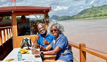 Couple enjoying a ride on a boat along a river.