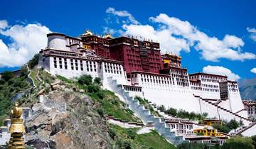 Large red and white palace on a hill under a bright sky.