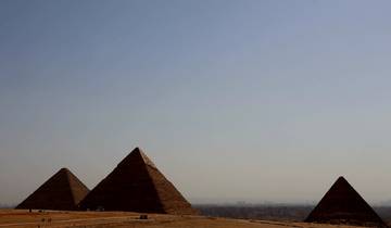 Three pyramids under a clear sky.