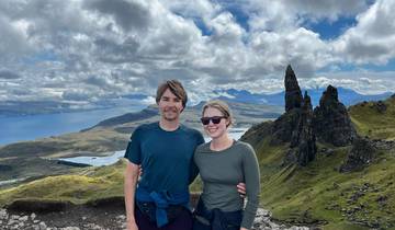 Couple with a scenic backdrop of mountains and water.