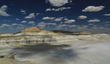 Dramatic landscape of white rocky formations under a blue sky.