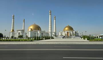 Magnificent white and gold mosque with multiple minarets.