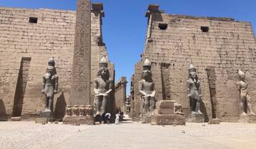 Luxor Temple with massive statues and tourists.