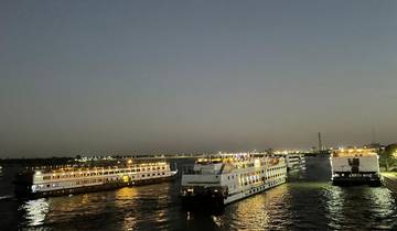 Boats on a river at night with city lights.