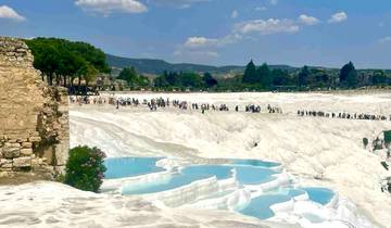 Tourists walking on the terraces of Pamukkale with mineral-rich thermal waters.