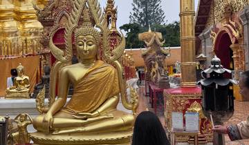 Golden Buddha statue in a temple courtyard.