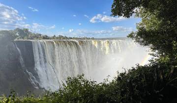 A majestic view of a large waterfall with a rainbow.