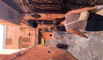 Tourists walking through a narrow alley with vibrant walls.