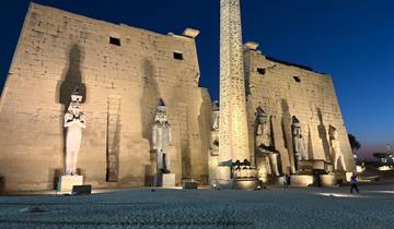 Luxor temple at night with a person walking.